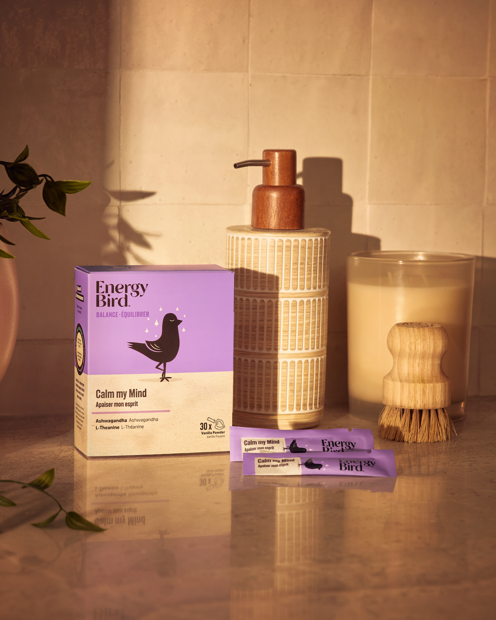 Supplément Apaiser mon esprit par Energy Bird sur une table en granit à côté d'un distributeur de savon et d'une bougie