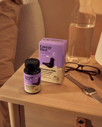 Energy Bird's Disconnect and Sleep bottle and packaging on a nighstand with a watch and glasses on it