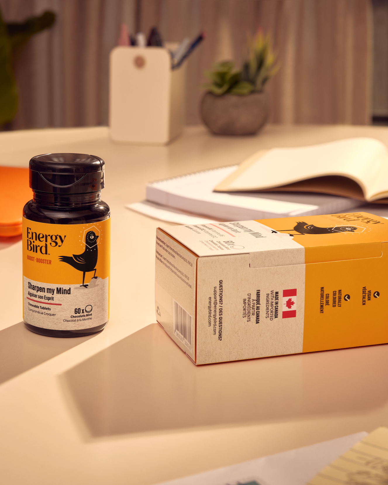 Energy Bird's Sharpen my Mind bottle and package on a table beside a notebooks and a pencil holder
